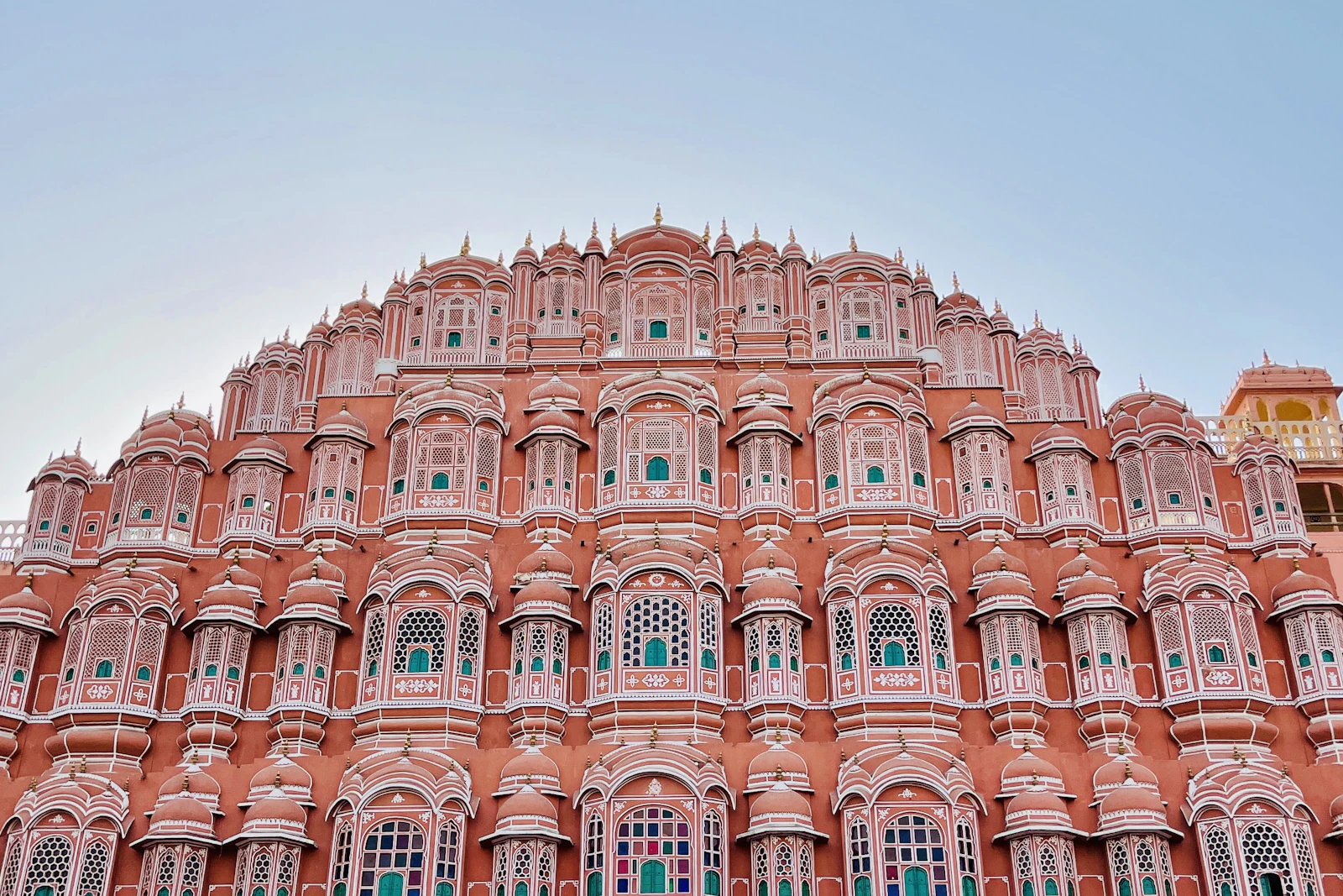 The tiered pink sandstone facade and latticed windows of Hawa Mahal in Jaipur