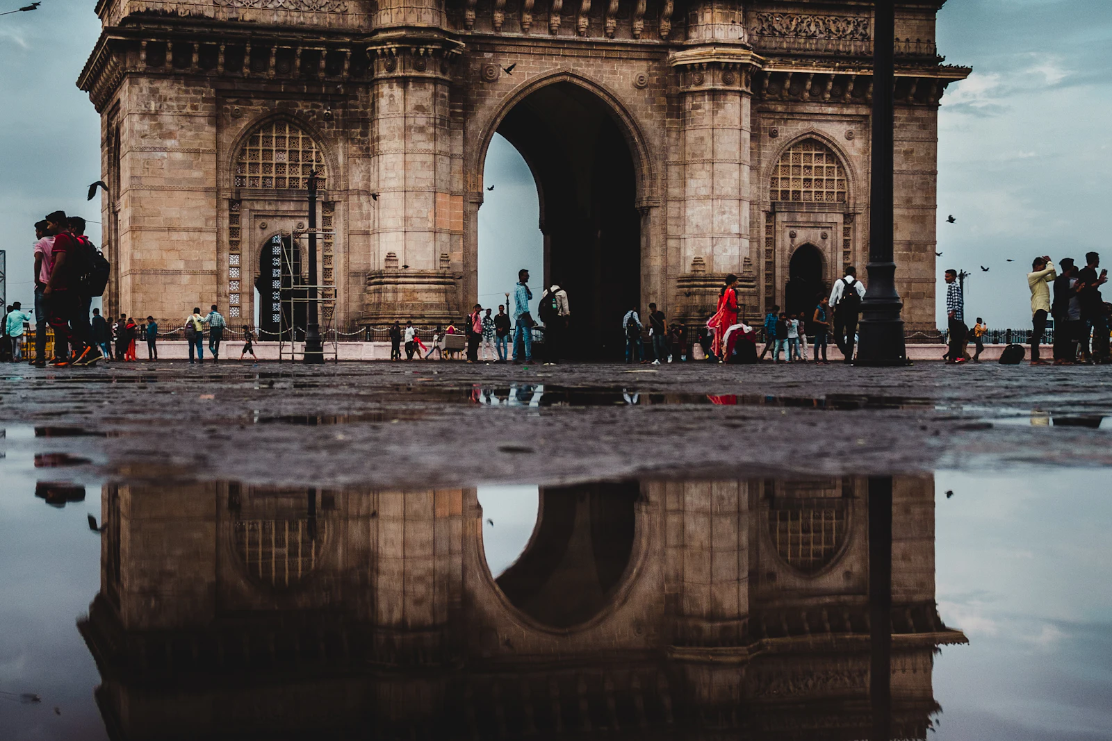 The Gateway of India in Mumbai mirrored in rainwater on the plaza in front of it